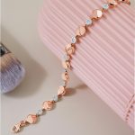 Stylish gold bracelet with diamonds on a pink background showcasing luxury jewelry.